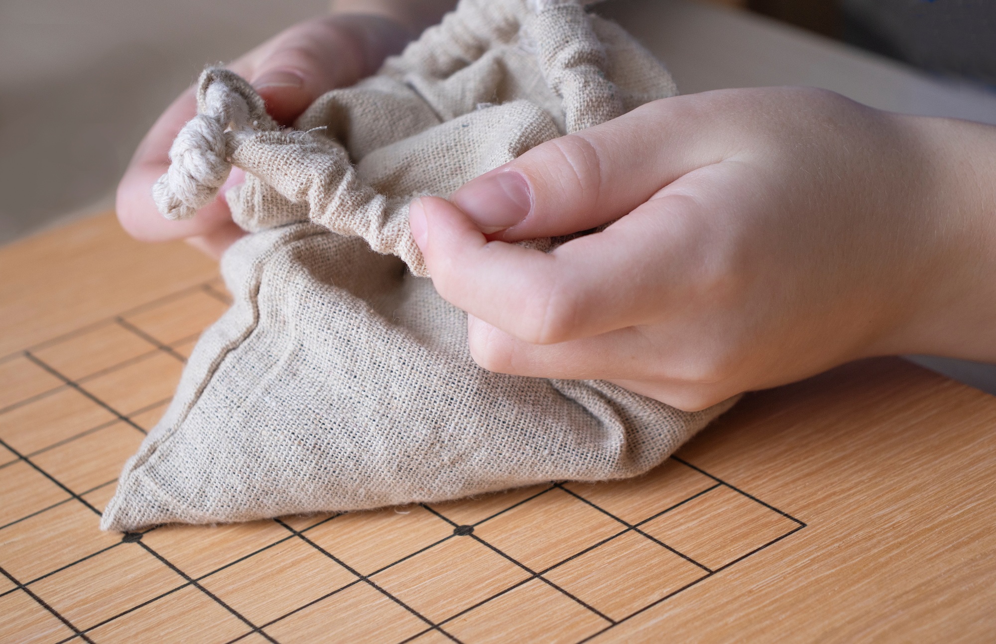 child plays the go game. Bag, board and stones close up